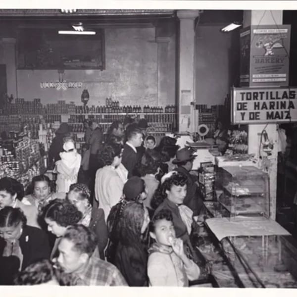 Black and white photo of a crowded La Luz del Día restaurant with people waiting in line.