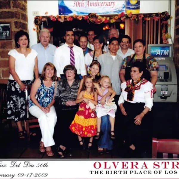 A large group of people, including children, celebrating La Luz del Día's 50th Anniversary.